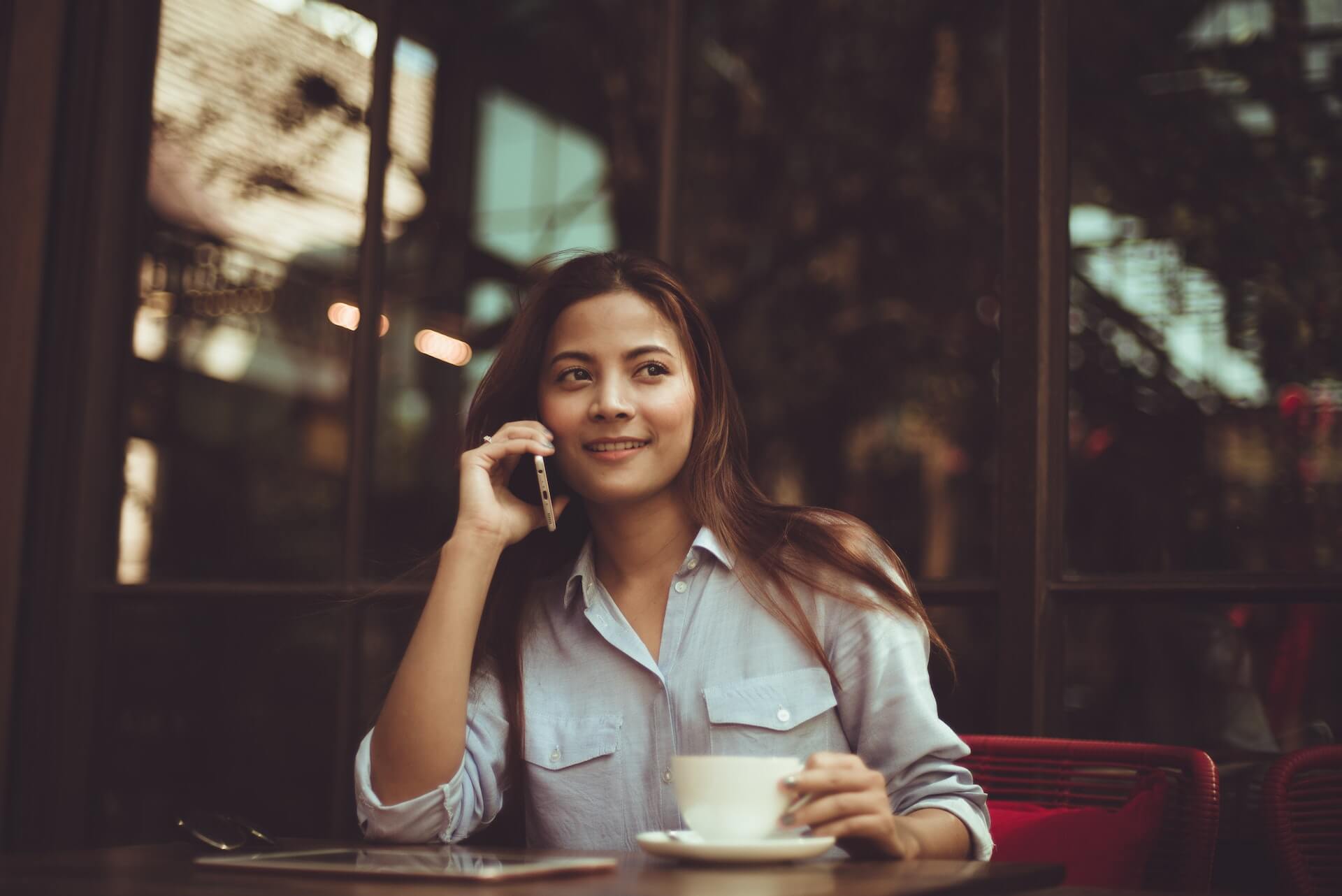 Frau am Telefon in einem Café