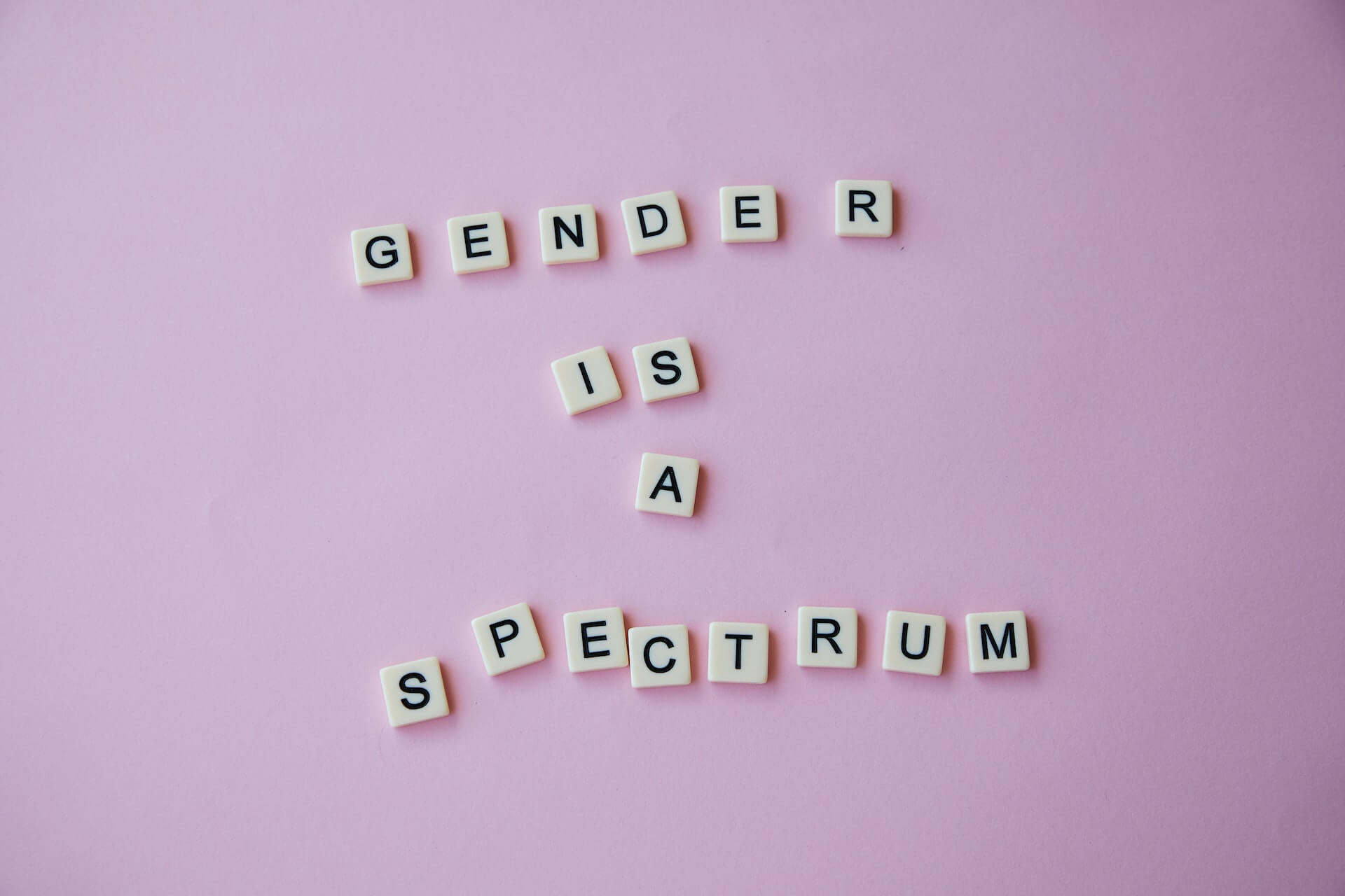 Würfel vor rosa Hintergrund: Gender is a spectrum