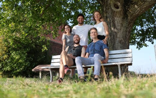 Fünf Menschen von der Supportive Sexwork Collective um eine Bank unter einem Baum