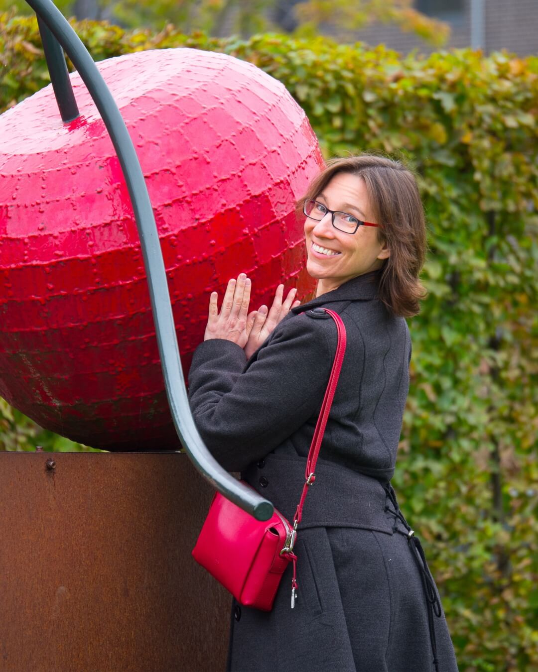 Independent Escort Jay im Herbstmantel vor einer Kirsche