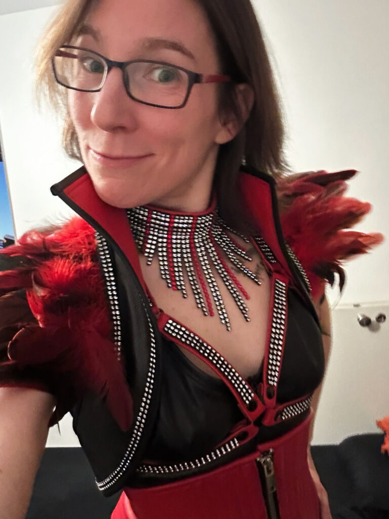 Jay in einem schwarz-roten Fetisch Outfit vor ihrer ersten privaten Play Party