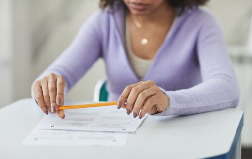 Eine junge Frau überlegt über einem Multiple-Choice-Test