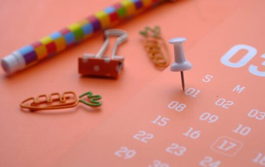 Termin Kalender auf pastell Untergrund mit Stecknadel und Klammern